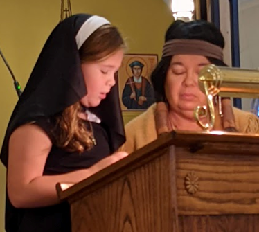 Little girl reading with her religious education teacher