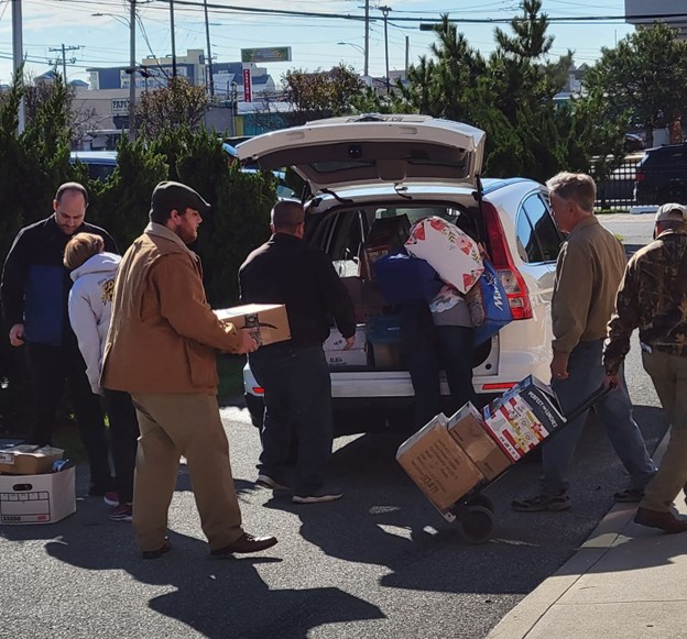 Group of Catholic ministers loading items into a white SUV