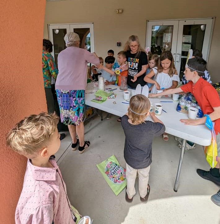 Volunteers and Children painting Easter eggs